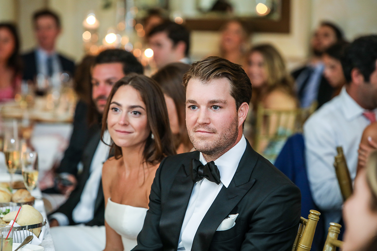a photojournalistic candid image of bride and groom listening to best man speech at wedding reception at Westchester Country Club in Rye Westchester County New York by Peter Oberc Wedding Photography