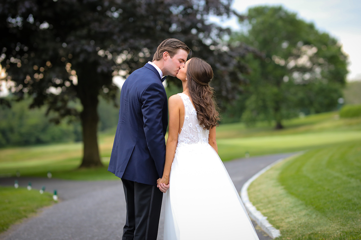A beautiful romantic bride and groom kiss as they candidly walk the grounds of Westchester Country Club in Rye, NY